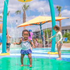 little girl cooling off in the florida heat in a splash pad park